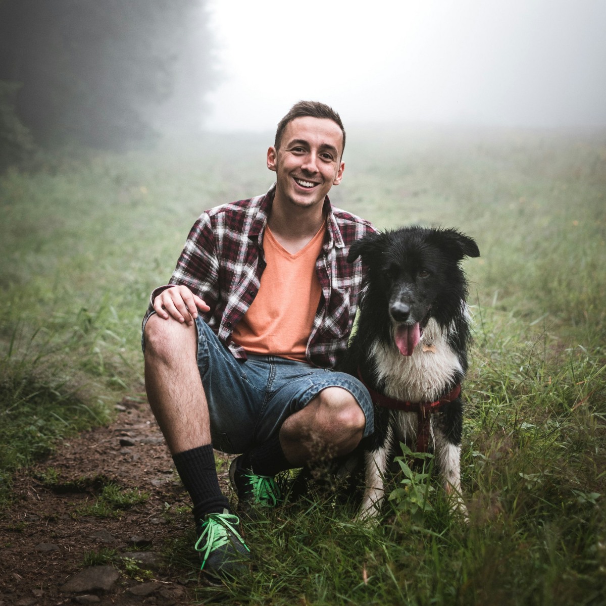 man and his dog sitting on grass
